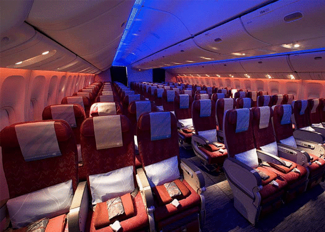 Empty Qatar Airways seats under soothing lights.