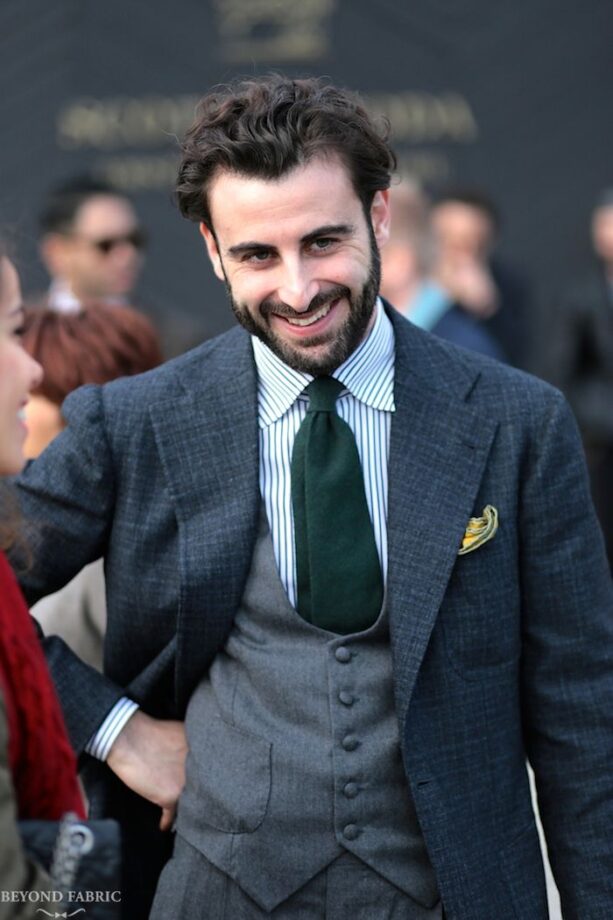 Man in gray suit smiling.