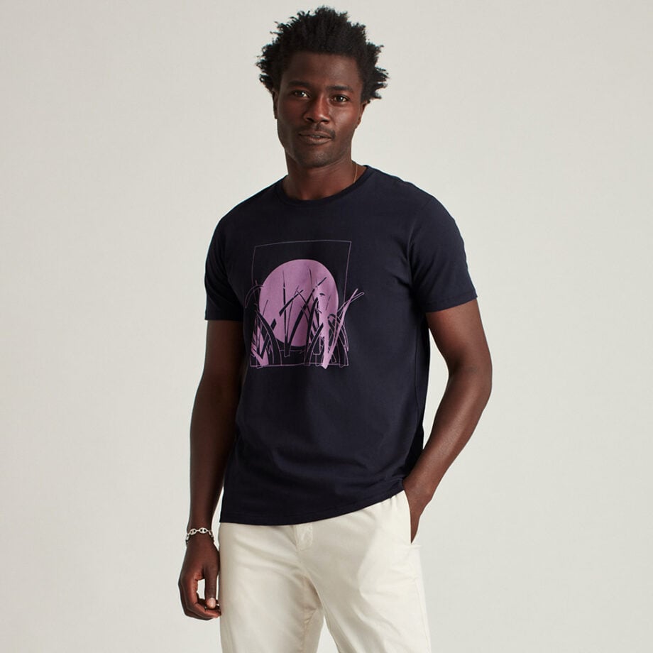 Person wearing navy T-shirt with pink design.