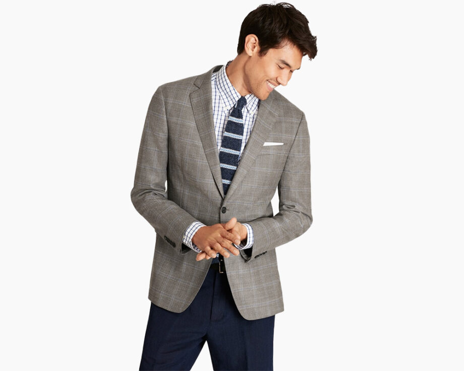 Man in workwear: gray blazer, checked shirt.