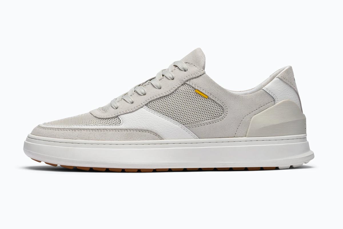 Stylish low-top gray sneakers with yellow tag.