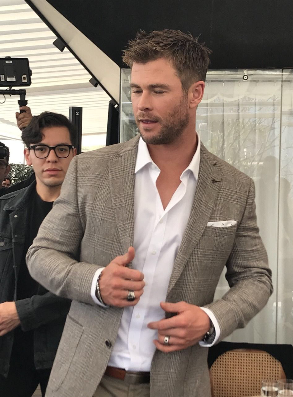Chris Hemsworth-style man gesturing indoors.