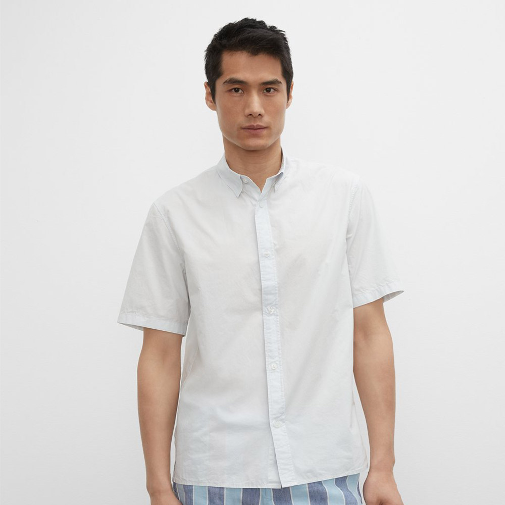 Man models casual shirt with striped pants.