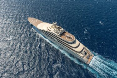 A luxury superyacht with helipad cruises ocean.