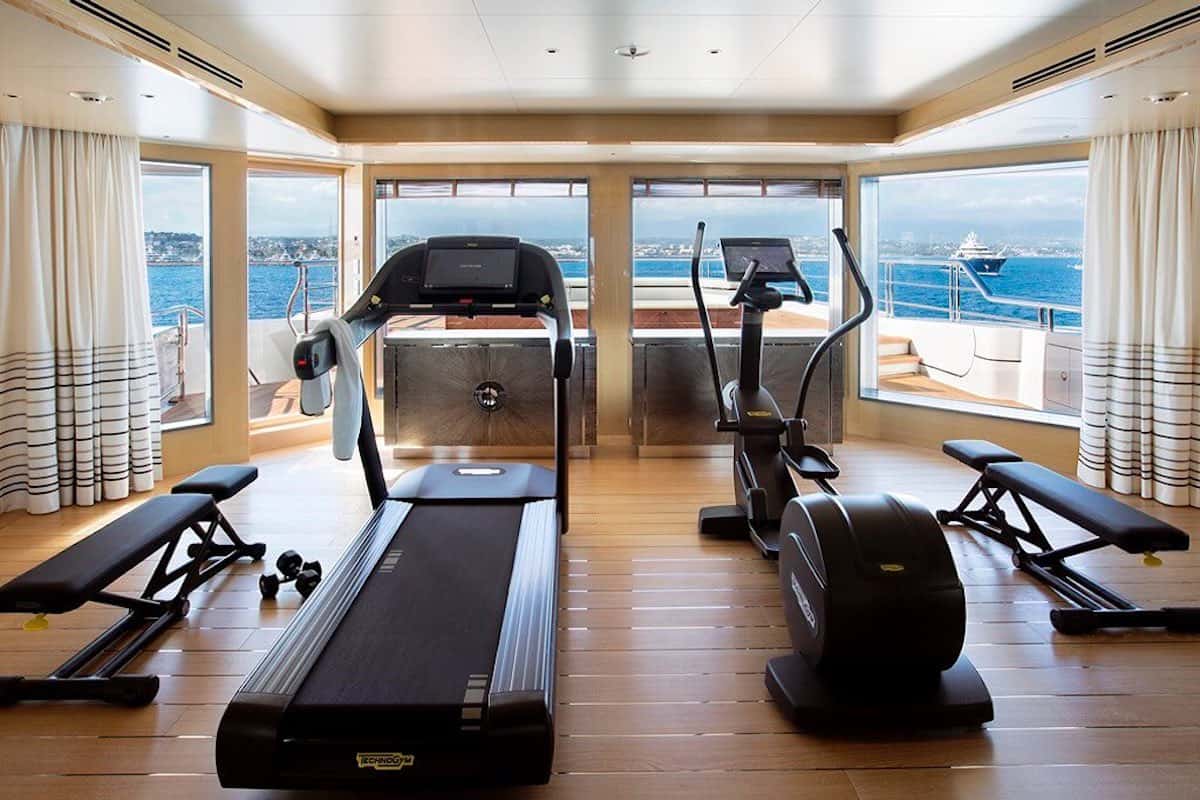 Superyacht gym: ocean views, equipment.