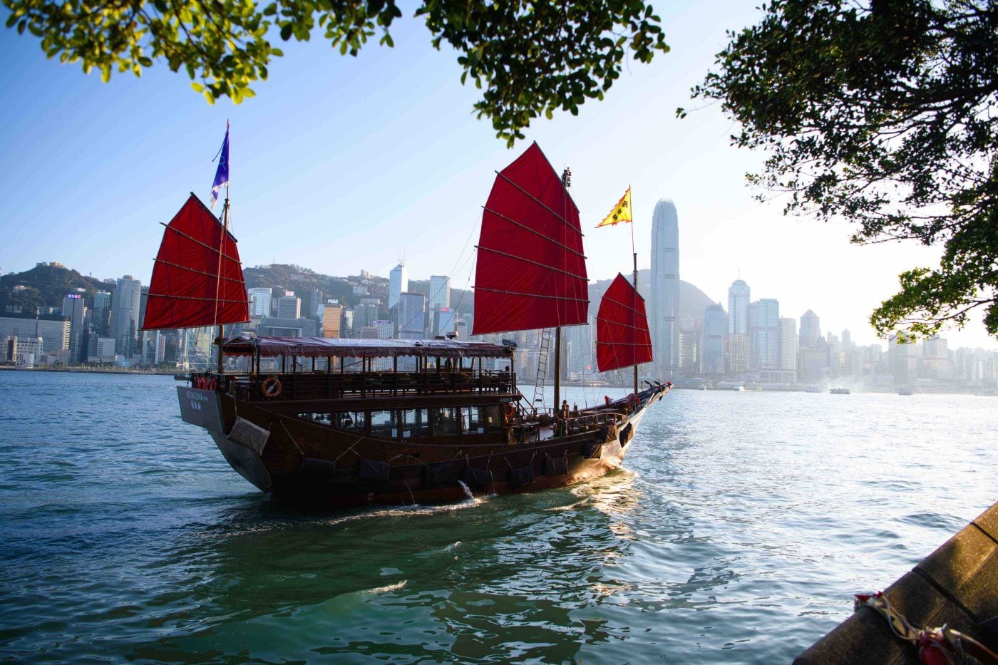 Aqua Luna junk boat with red sails sailing across Victoria Harbour, hong kong. 