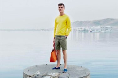 Man in colorful outfit, waterfront.