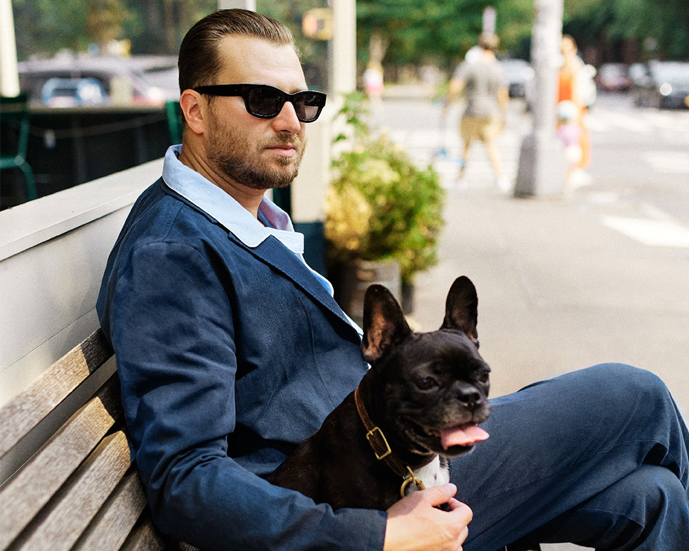 Man with French bulldog, wearing top brands.