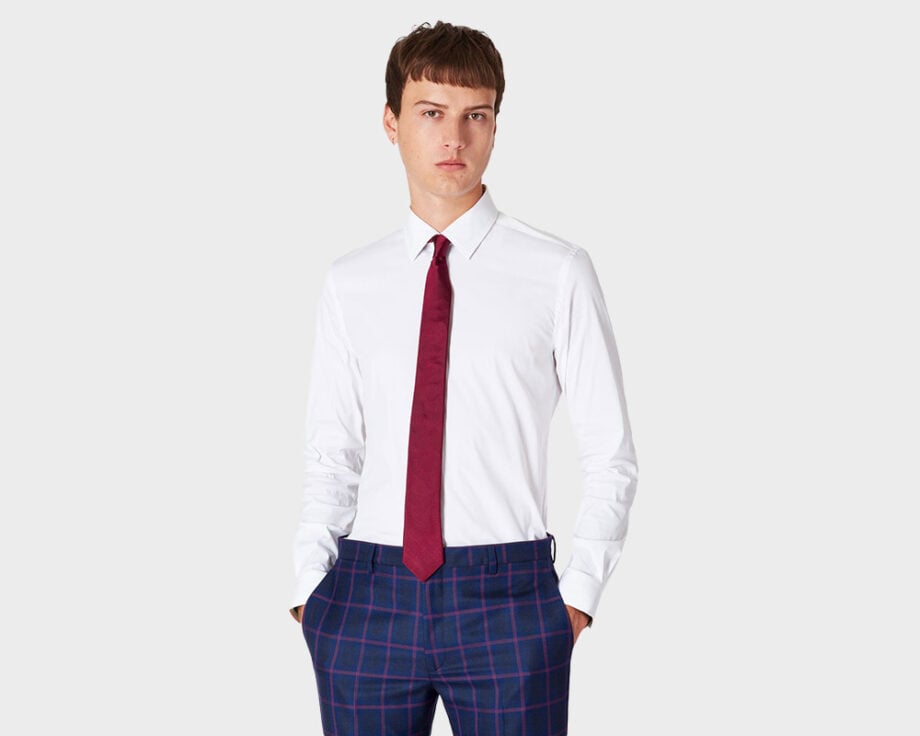 Man in white shirt, red tie, blue plaid pants.