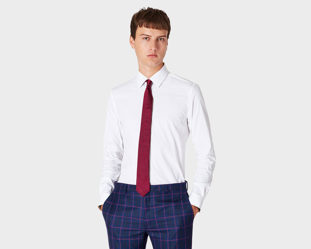 Man in white shirt, red tie, blue plaid pants.