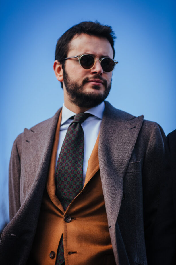 Man in stylish attire outdoors.