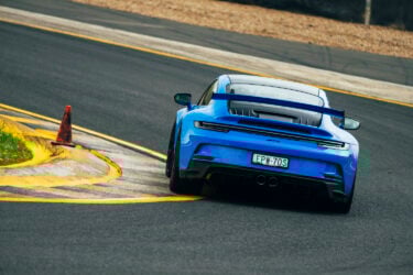 Blue Porsche 911 GT3 races on track.