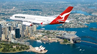 A Qantas A380 flies over Sydney landmarks.