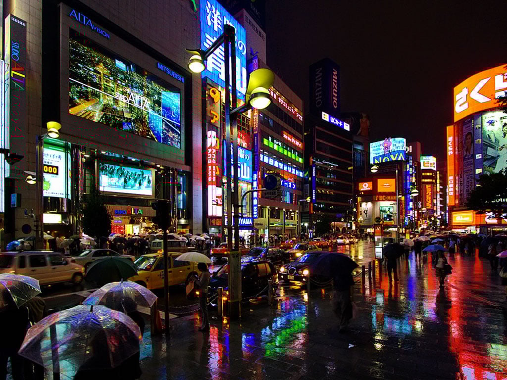 Bustling Tokyo night, colorful neon signs, crowds with umbrellas.