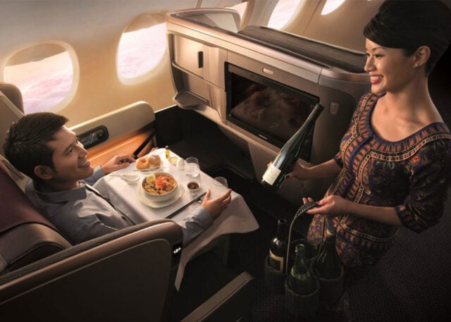 Man enjoys meal in luxurious Singapore Airlines Business Class.