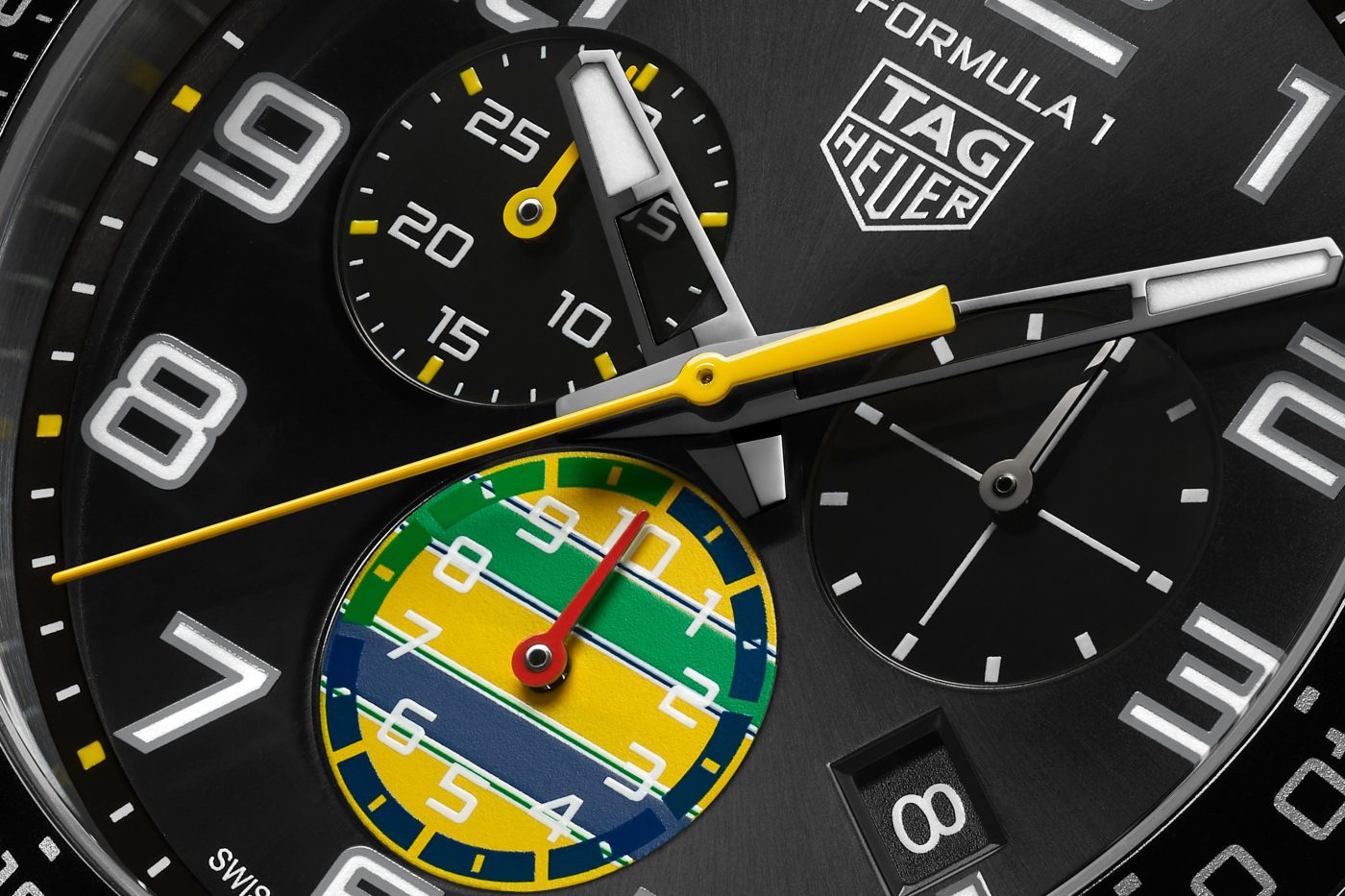 Close-up of the dial on the TAG Heuer Formula 1 Chronograph x Senna 44 mm — a black sunray-brushed finish with vivid yellow and green accents inspired by Senna’s helmet. Image: TAG Heuer