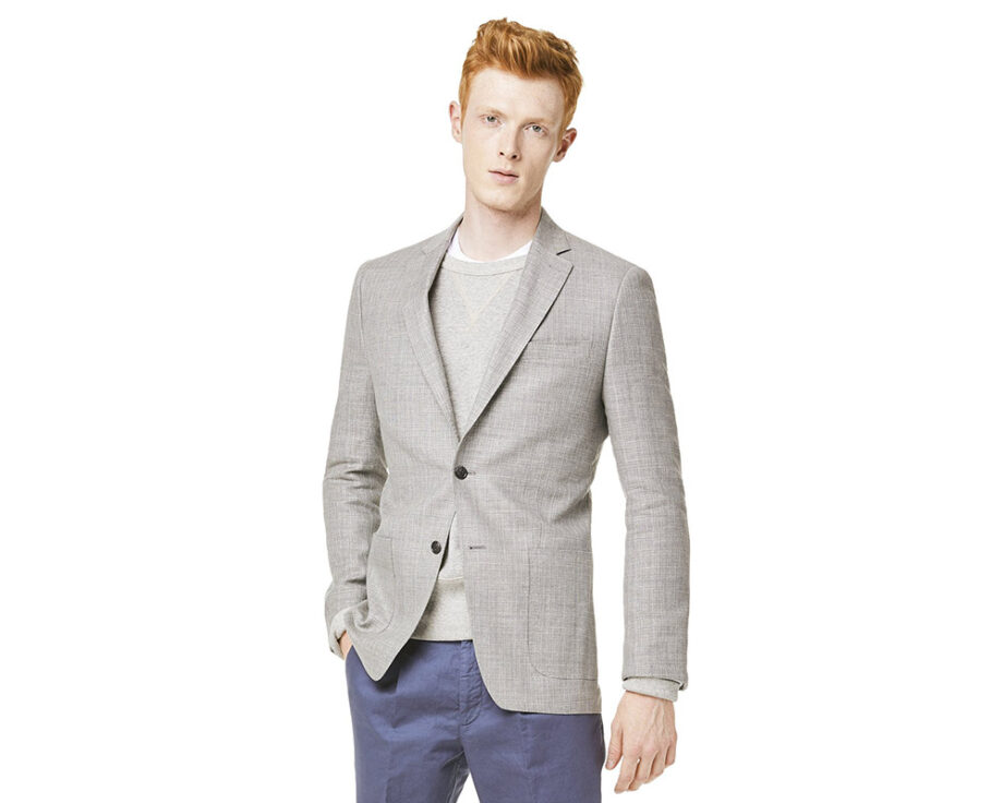 Modeling work attire: blazer, sweater, blue pants.