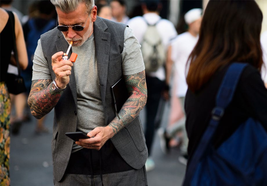 Tattooed man in suit vest.