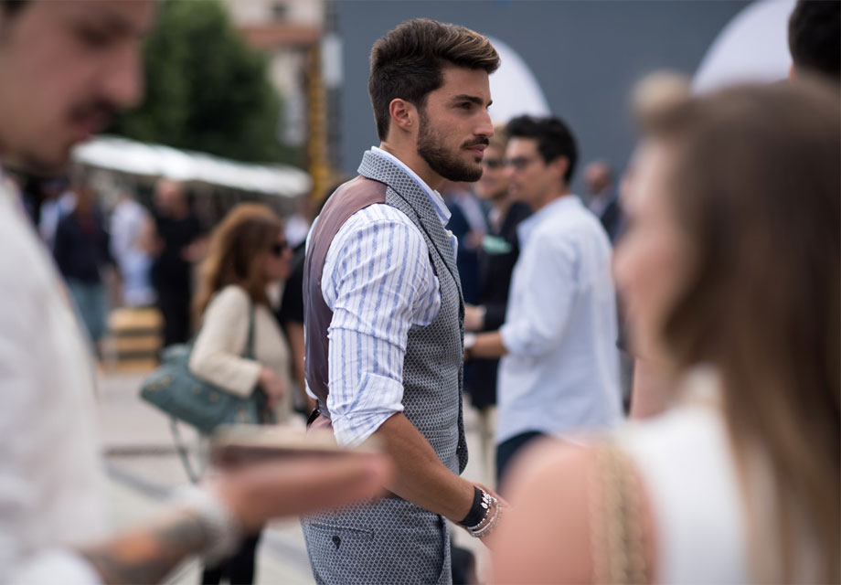 Bearded man stylishly dressed outdoors.