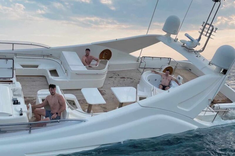 Three men enjoy yacht off Greece's coast.