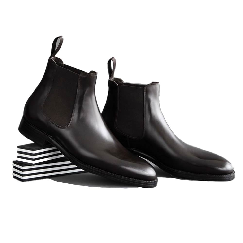 Dark brown Chelsea boots on striped boxes.